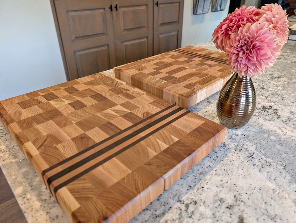 Two handcrafted end-grain cutting boards displayed on a stone counter