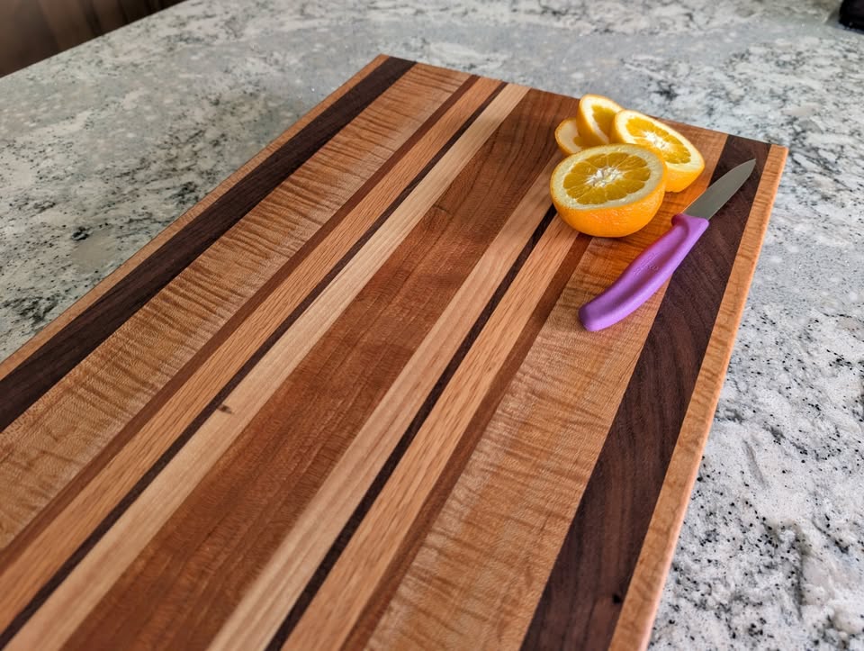 Striped edge-grain cutting board with sliced oranges